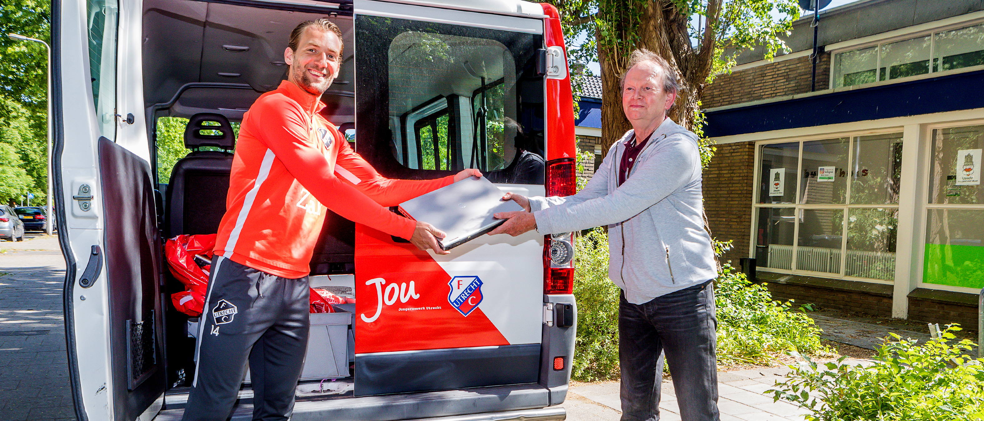 Willem Janssen overhandigt laptops aan Stichting JoU